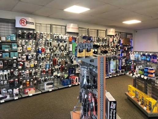 Interior of a RadioShack store with walls and freestanding racks densely stocked with cables, adapters and electronic accessories.