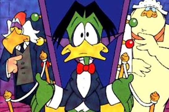 Count Duckula gestures between Igor and Nanny in a colourful cartoon scene.