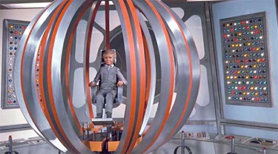 Joe 90 seated inside the spherical BIG RAT machine surrounded by control panels.