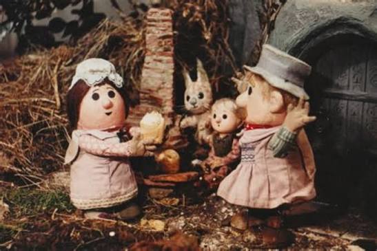 Colour still of the Pogle family and a rabbit outside their woodland home.