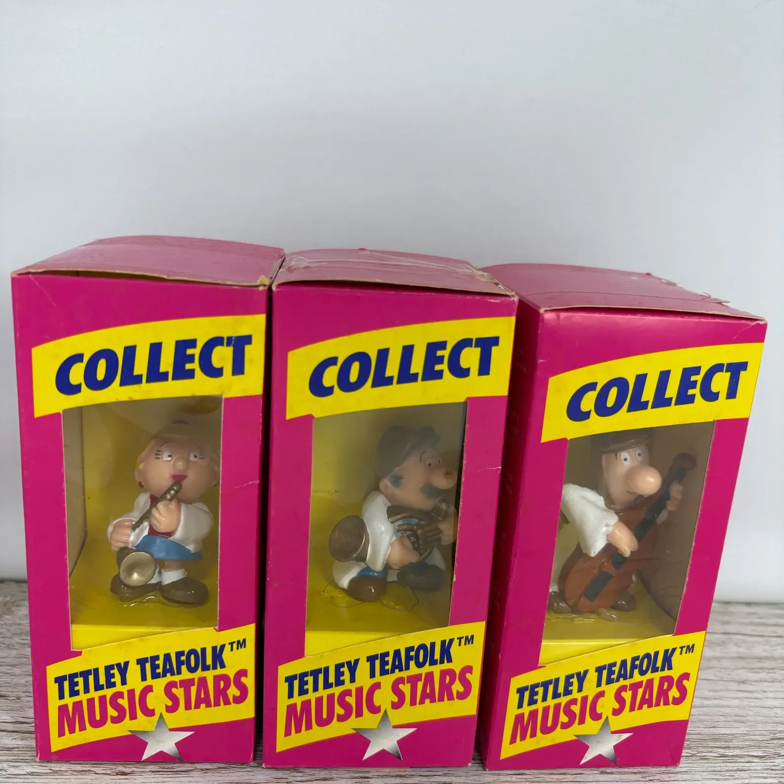 Three boxed Tetley Tea Folk Music Stars figurines holding musical instruments.