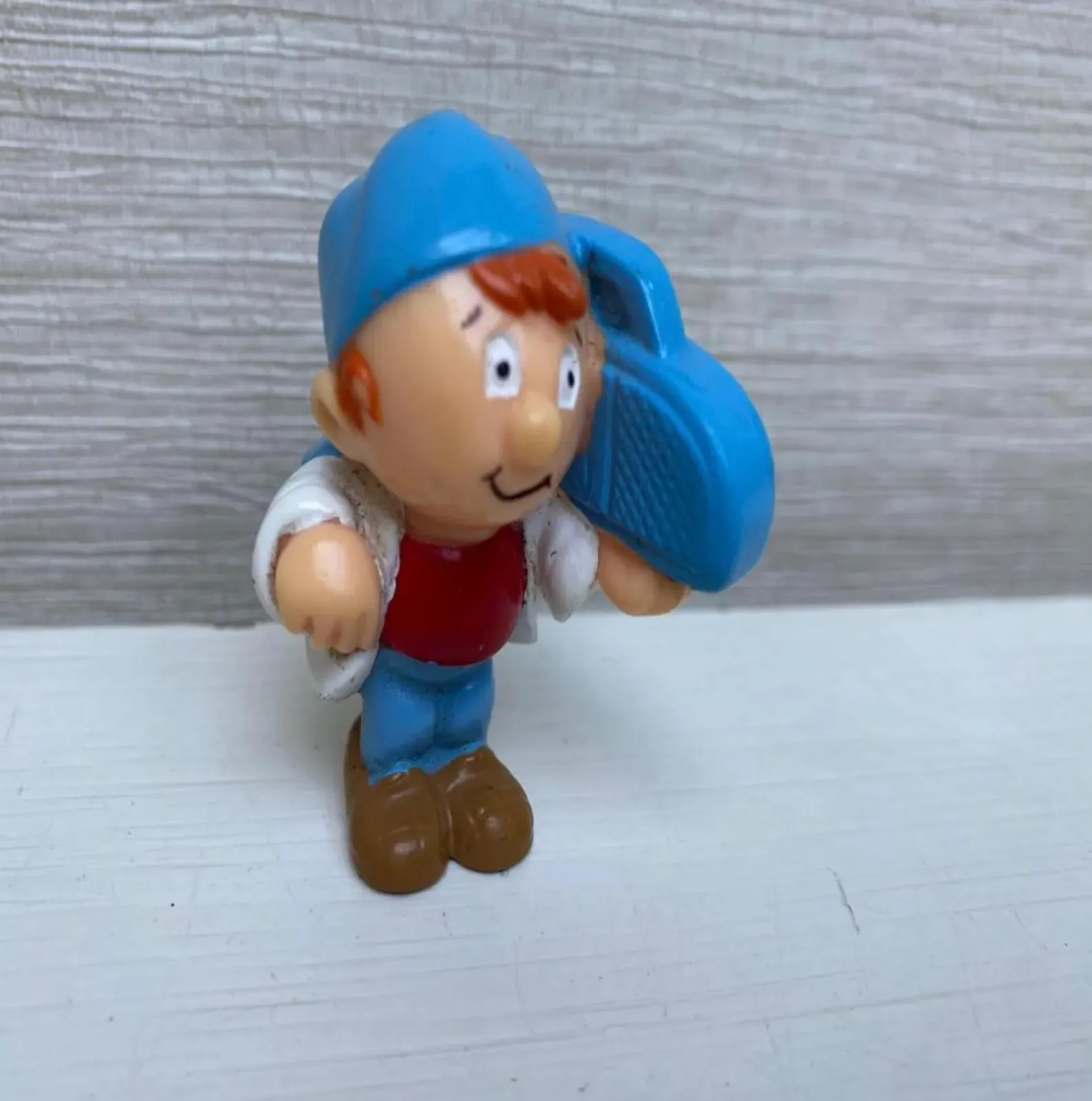 Tetley Tea Folk figurine of a red-haired delivery boy carrying a large blue sack.