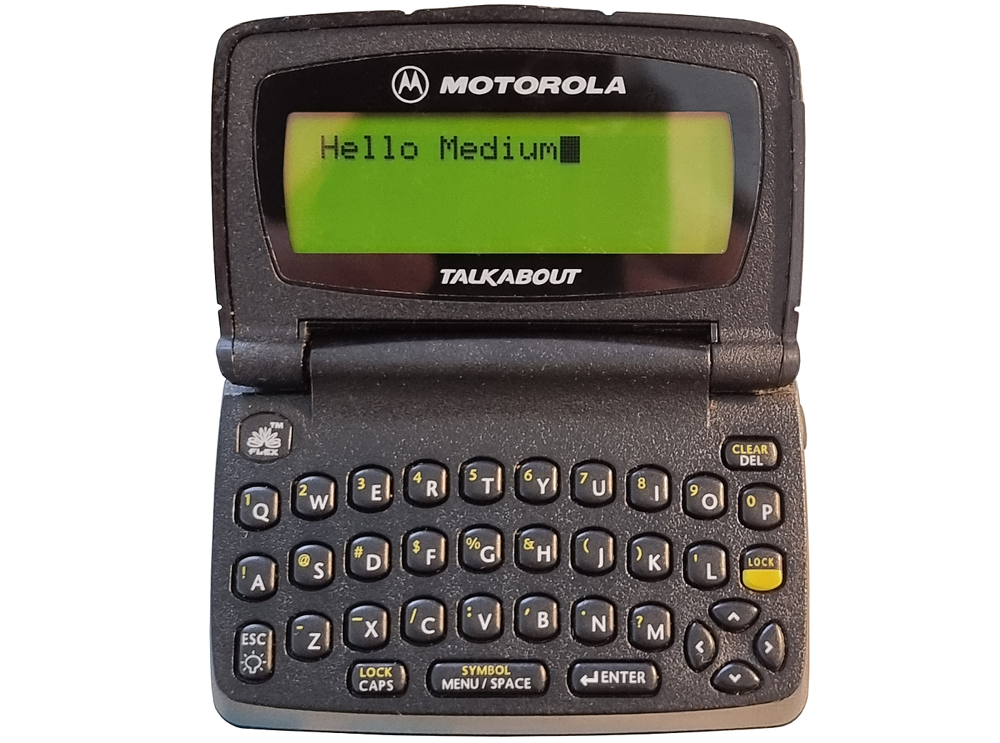 Front view of a black Motorola Talkabout pager with its flip-up screen open; the green display reads “Hello Medium,” above a compact QWERTY keyboard with yellow secondary labels.