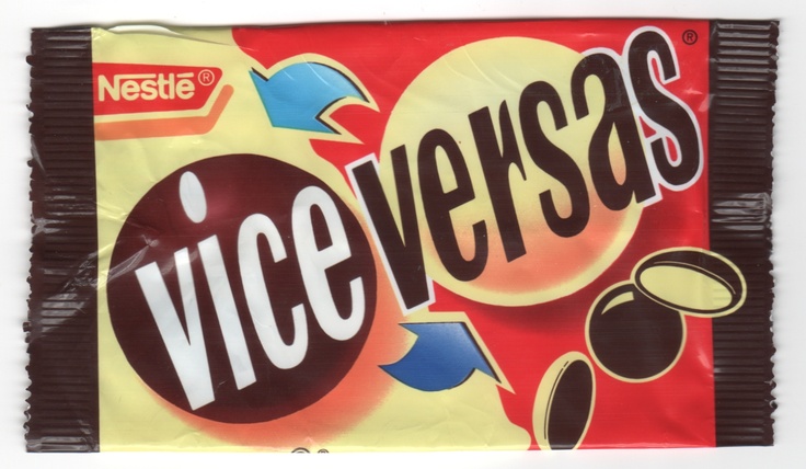 Front of a Nestlé Vice Versas confectionery wrapper, split into pale yellow and red sections with large brown-and-white “Vice Versas” lettering, blue curved arrows, chocolate-coloured circles, and dark brown sealed ends.