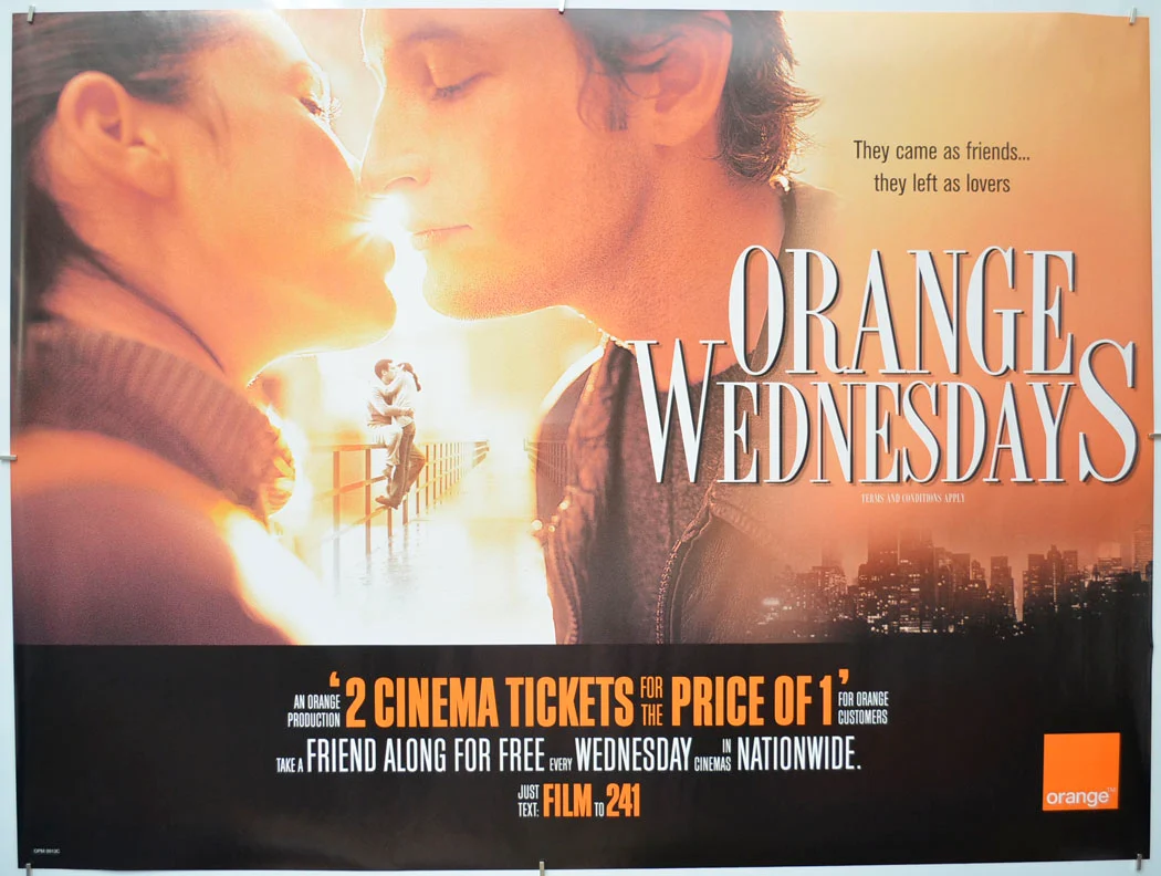 Orange Wednesdays promotional poster styled like a romantic film poster. A woman and man face each other in warm sunlight above a city skyline; text reads “They came as friends… they left as lovers” and advertises two cinema tickets for the price of one for Orange customers.