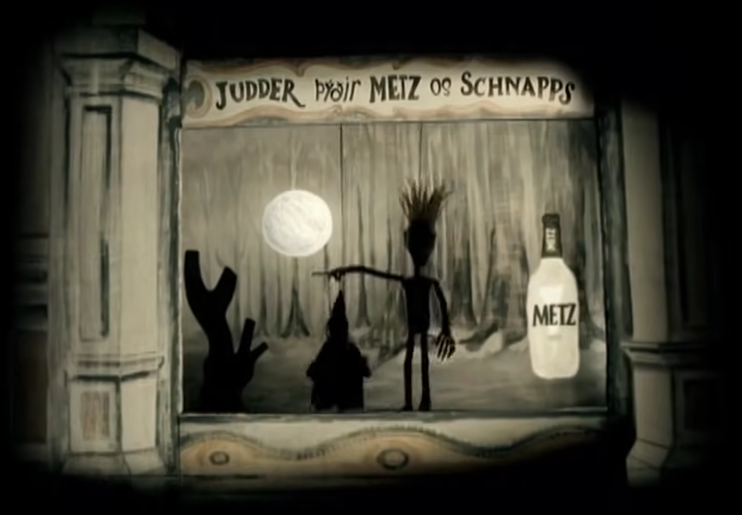 Dark, vignetted image of a painted shop-window display. A sign reads “JUDDER pÿair METZ os SCHNAPPS” above a moonlit forest scene with black silhouettes of a tall spiky-haired figure with outstretched arms, a small pointed figure, and a raised-arm shape; a bottle labeled “METZ” stands at right.