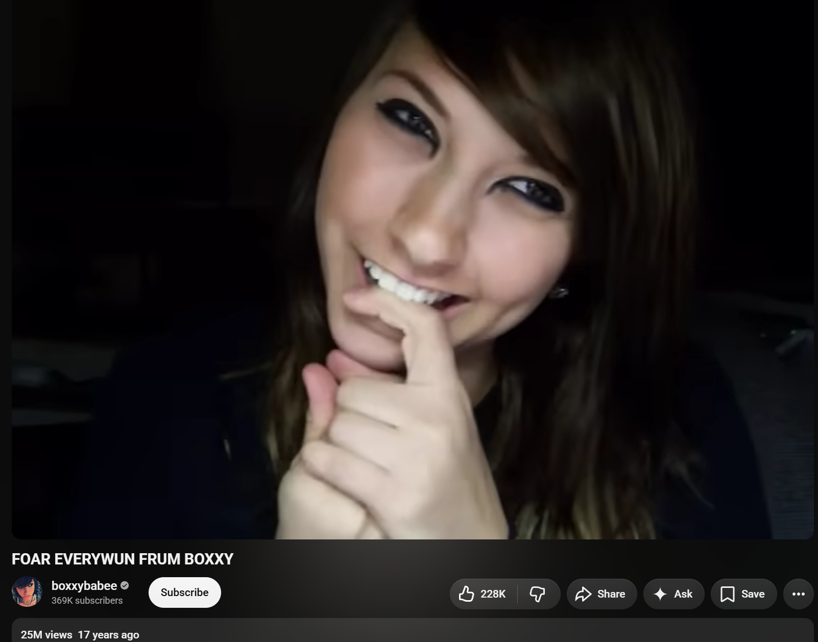 Screenshot of a video page showing a smiling young woman with long brown hair and heavy black eyeliner holding a hand near her mouth; visible text includes “FOAR EVERYWUN FRUM BOXXY,” “boxxybabee,” “369K subscribers,” “228K,” and “25M views 17 years ago.”