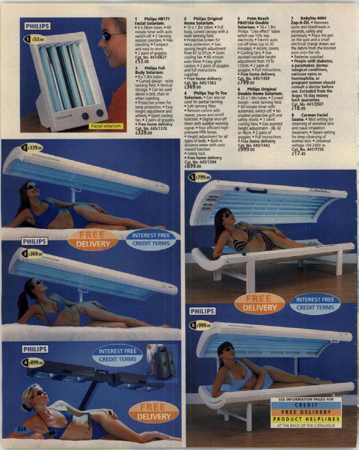A full-page Argos catalogue spread shows six tanning products. One panel advertises a Philips Top to Toe Solarium with a reclining woman wearing protective glasses beneath an overhead lamp unit.