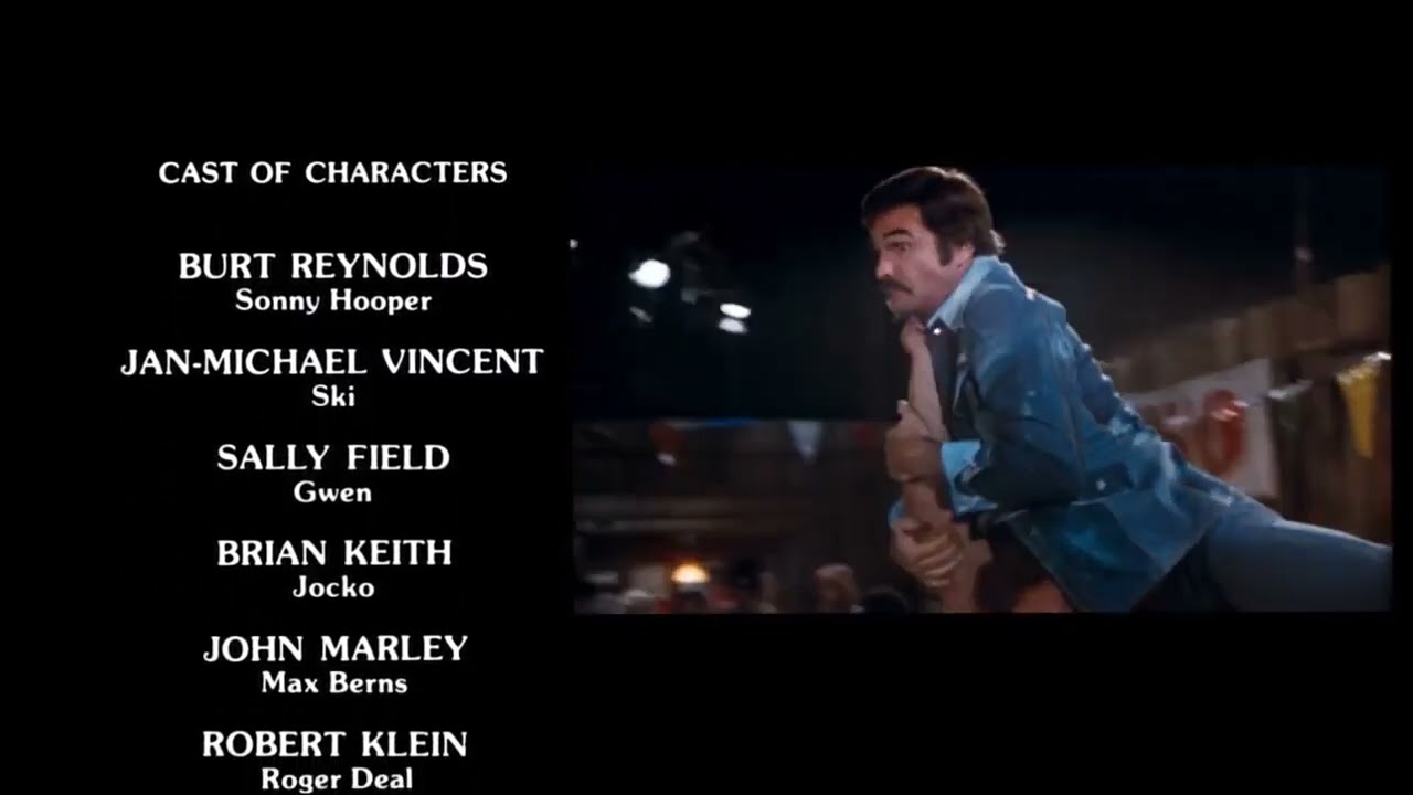 On a black background, white cast credits list Burt Reynolds, Jan-Michael Vincent, Sally Field, Brian Keith, John Marley and Robert Klein at left; at right, an inset film frame shows a moustached man in a blue jacket grappling with another person.