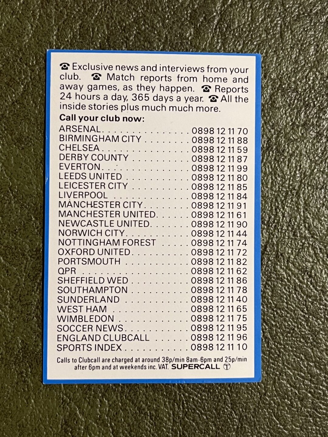 White card with a blue border on a textured dark surface, headed by text promising club news, interviews and match reports. Below is a list of football clubs and 0898 telephone numbers, followed by call charges and a Supercall logo.
