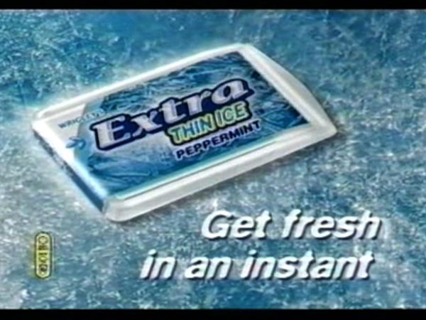 Low-resolution video frame showing a closed white plastic dispenser labeled “Wrigley’s Extra Thin Ice Peppermint” on an icy blue background. Large white text reads “Get fresh in an instant,” and black borders frame the image.