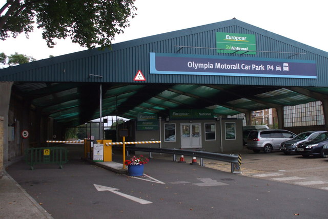 An entrance canopy reads Olympia Motorail Car Park P4 above parked cars and car-rental signs.