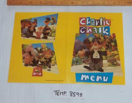 Yellow folding Brewers Fayre children’s menu featuring the colourful Charlie Chalk logo, the clown character and scenes with his friends.