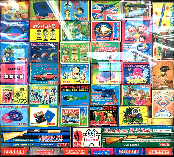 An assortment of Cosmos toy-package designs, illustrating the colourful novelty prizes promoted through the company's vending machines.