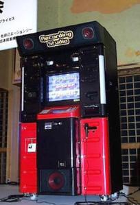 Tall red-and-black RECOSTA karaoke recording machine with an illuminated screen, standing indoors.