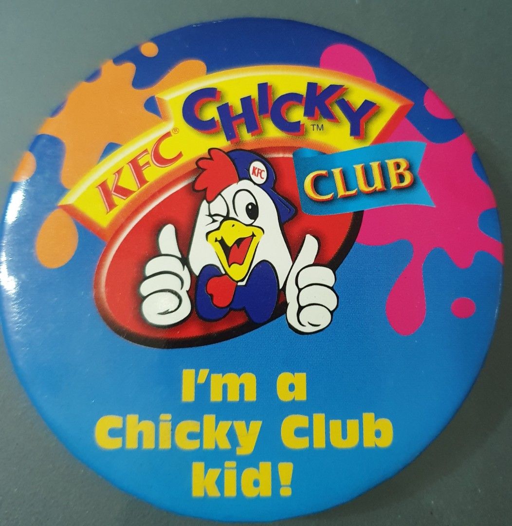 Round blue KFC Chicky Club badge with a smiling cartoon chicken giving two thumbs up, colourful background shapes and yellow membership slogan.