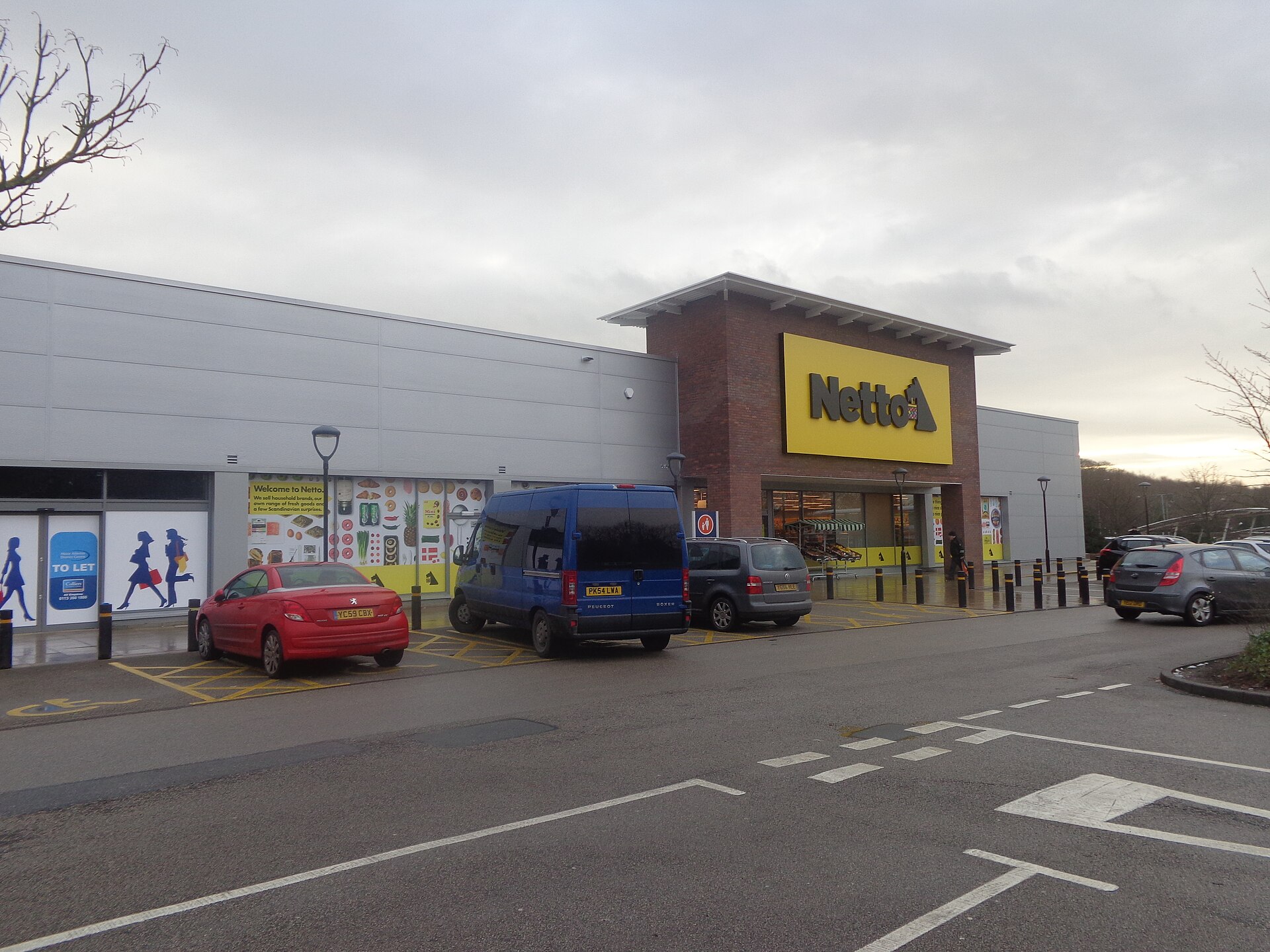 A Netto supermarket with a large yellow sign and Scottie-dog logo faces a car park at Moor Allerton in Leeds.