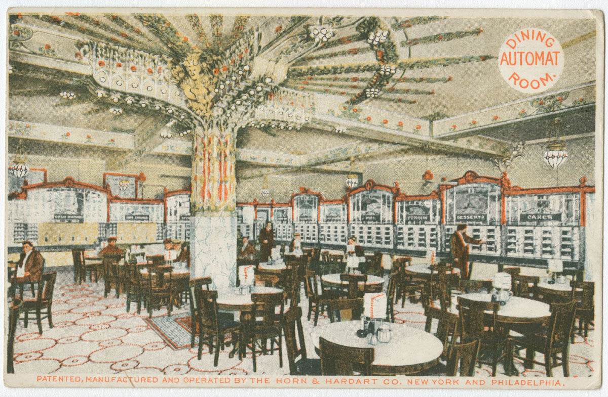 A colour printed postcard of an ornate dining room with round tables, wooden chairs and rows of labelled food compartments along the walls.