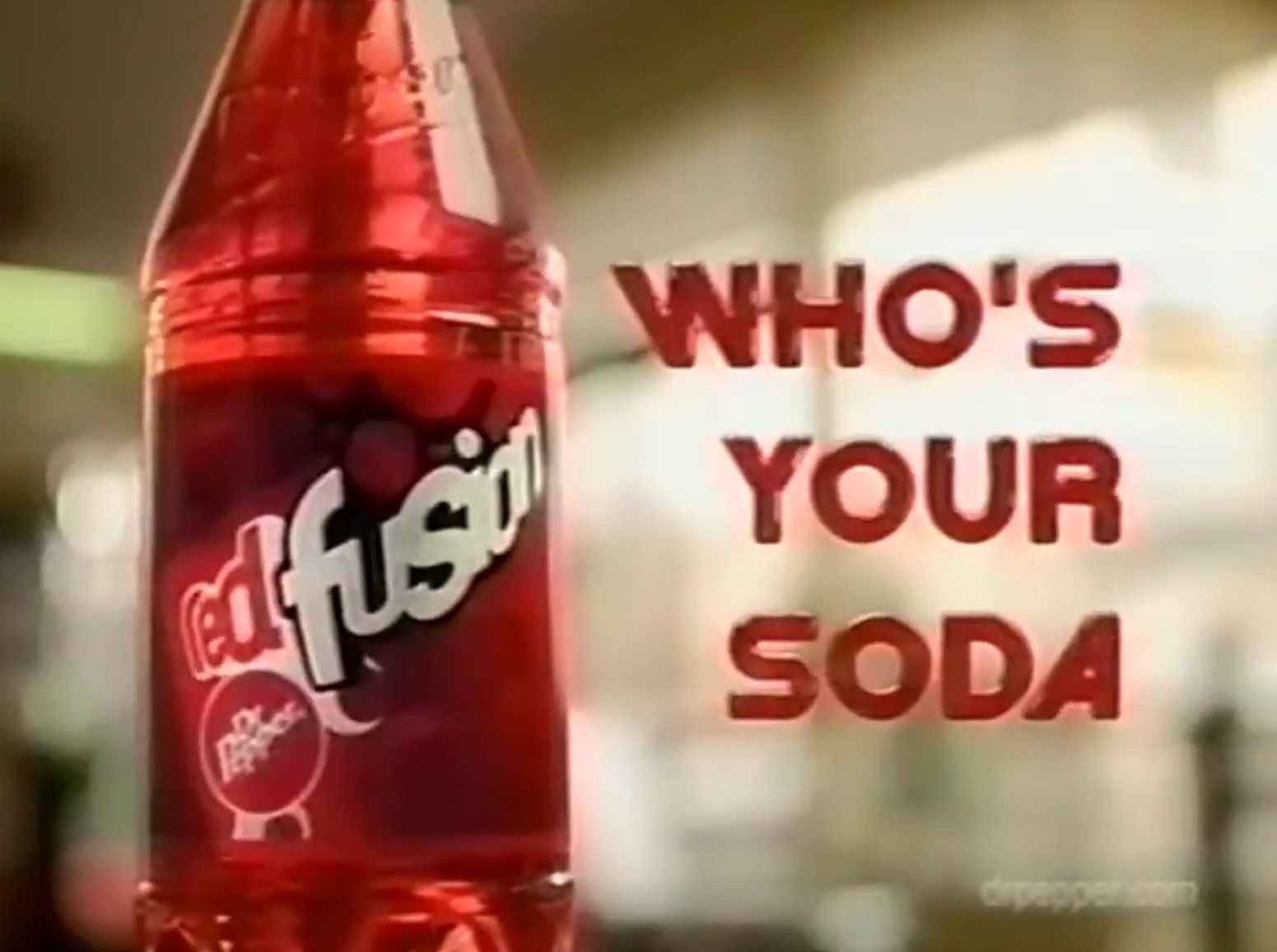 Frame from a Red Fusion advert showing a red bottle with a large Red Fusion wordmark and smaller Dr Pepper logo beside the words “WHO’S YOUR SODA”.