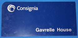 Blue sign reading Consignia with a circular multicolour emblem.