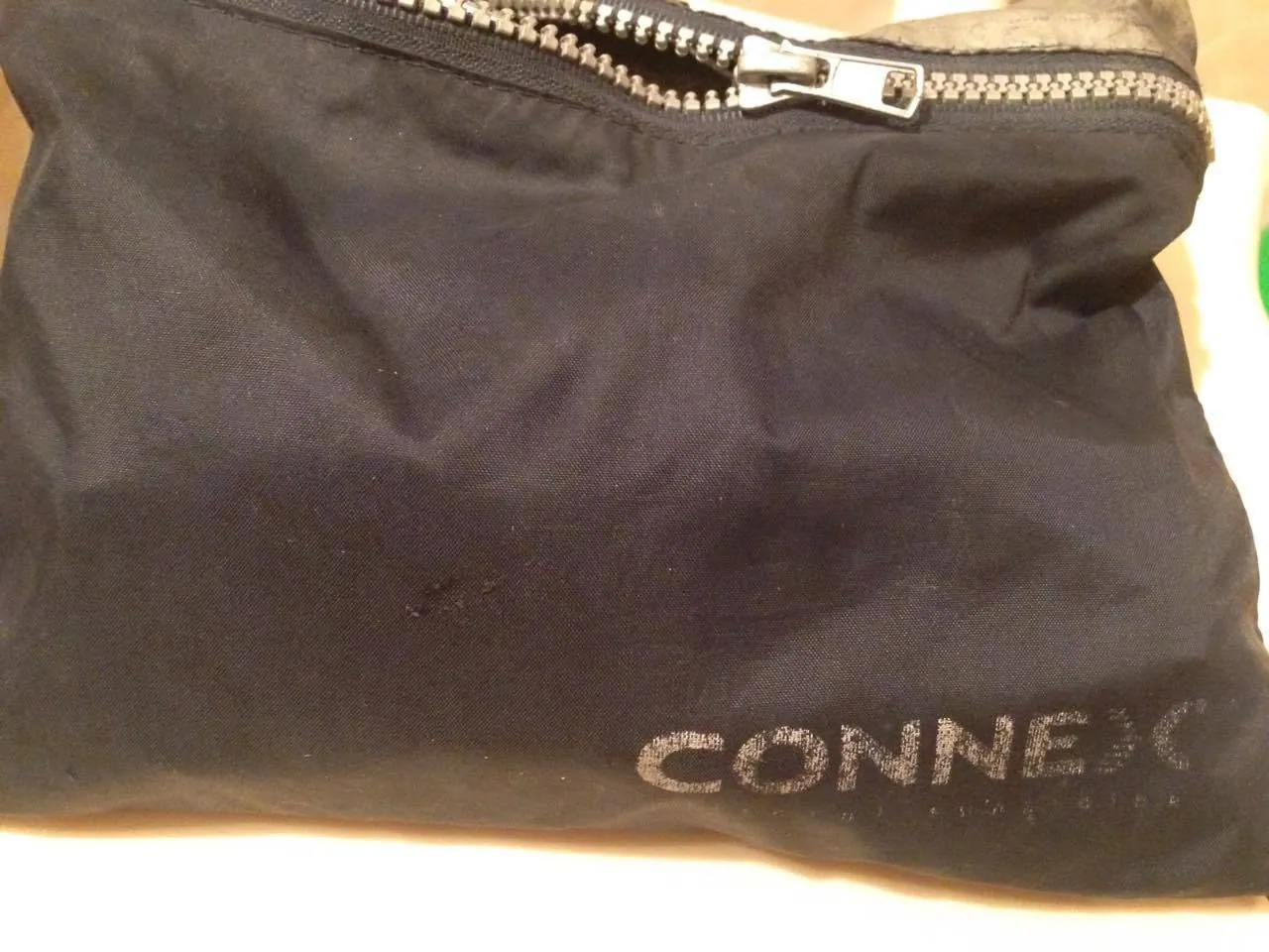 Black zippered fabric phone pocket with faded CONNEX branding.