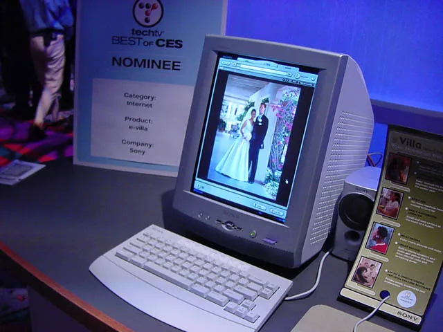 Sony eVilla with a portrait screen, white keyboard and matching mouse on a blue-lit exhibition stand.
