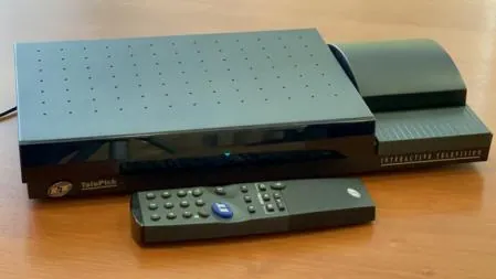 Telepick terminal with an integrated printer on the right and a remote control lying in front.