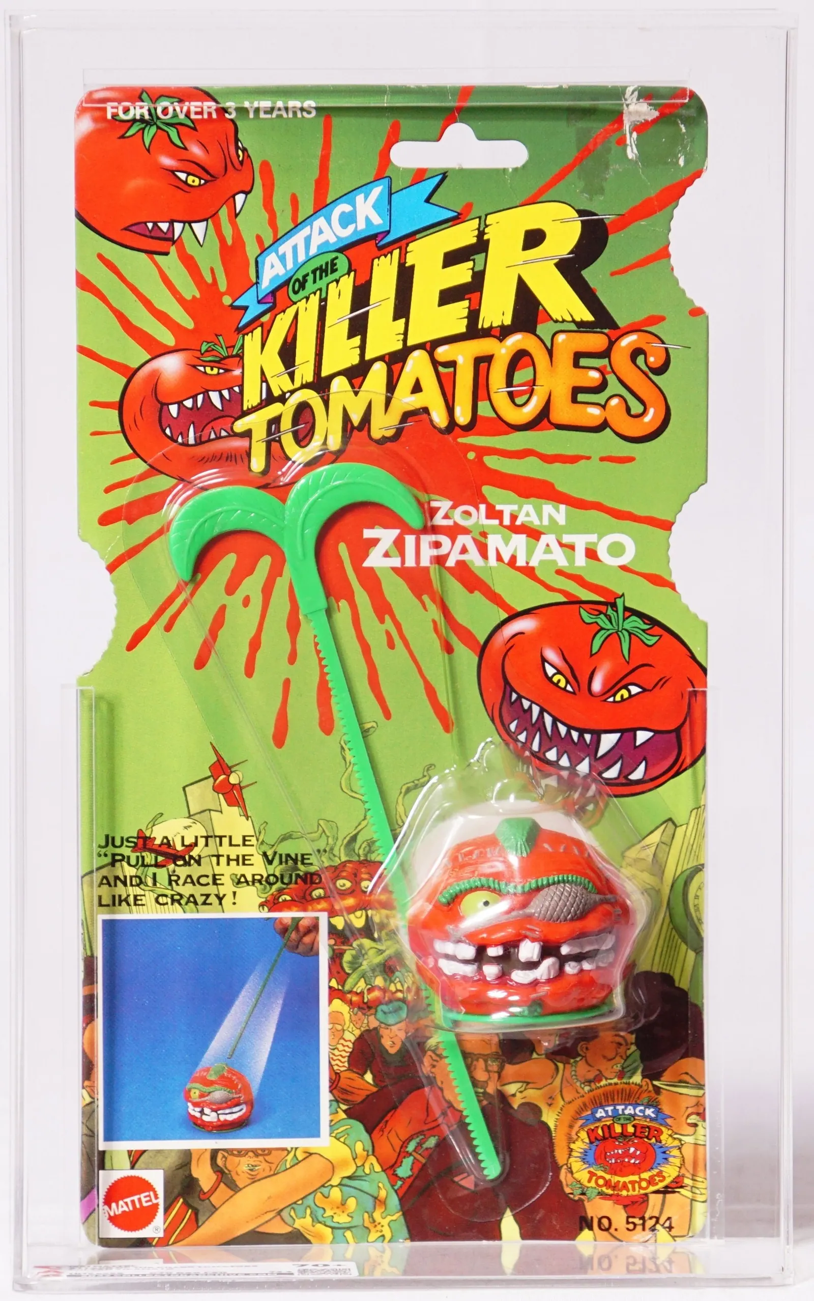 Close front view of a carded Mattel Attack of the Killer Tomatoes Zoltan Zipamato toy in a clear protective case. The green card has red splatter graphics and tomato characters; the red tomato-shaped toy and green zip cord are visible in the blister.