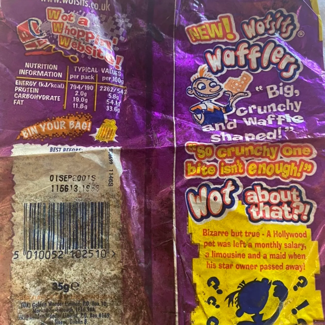 Flattened, creased purple Wotsits Wafflers snack wrapper showing the logo, a cartoon figure holding a rectangular waffle-shaped snack, the phrases “Big, crunchy and waffle shaped!” and “So crunchy one bite isn’t enough!”, nutrition information, a barcode and a printed code label.