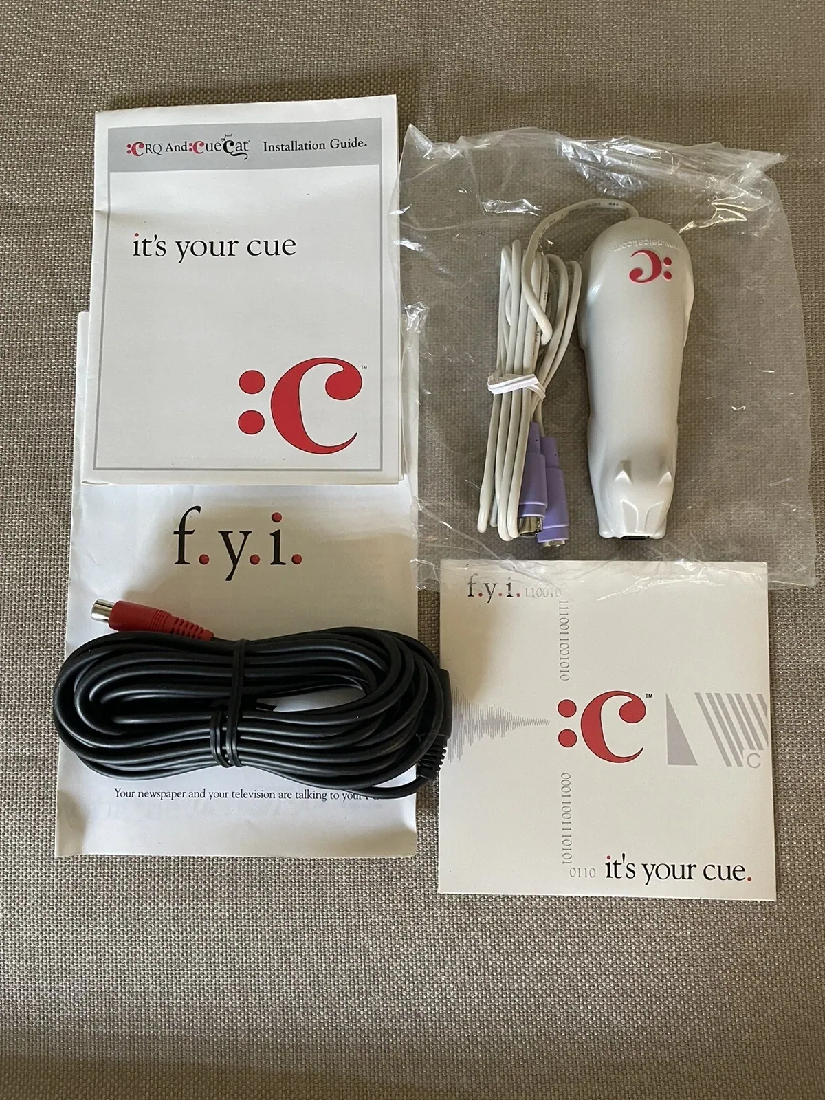 Original CueCat barcode scanner with cables, packaging and printed Digital Convergence documentation.