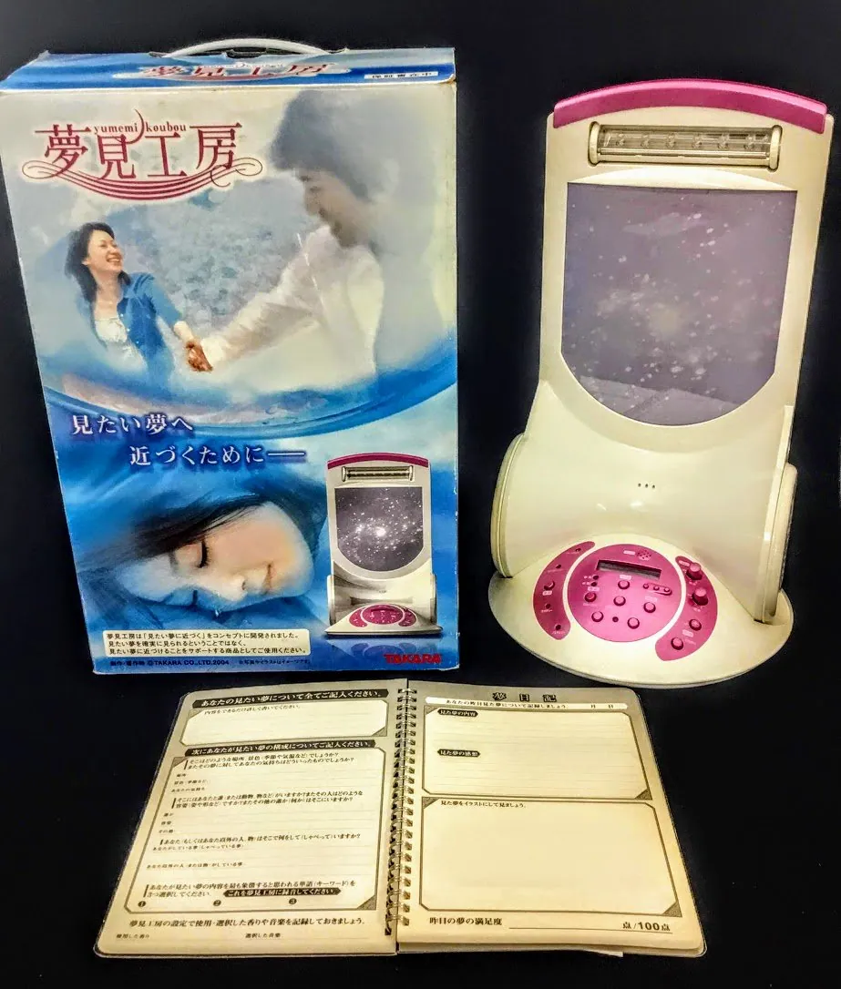 Takara Yumemi Kobo dream machine displayed with its original packaging and open dream journal.