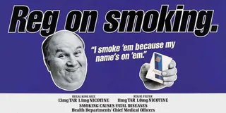Blue Embassy Regal cigarette advert reading “Reg on smoking.” A black-and-white cut-out portrait of a smiling bald man appears beside the line “I smoke ’em because my name’s on ’em.” and a hand holding a Regal pack. Tar, nicotine and smoking warning text runs along the bottom.