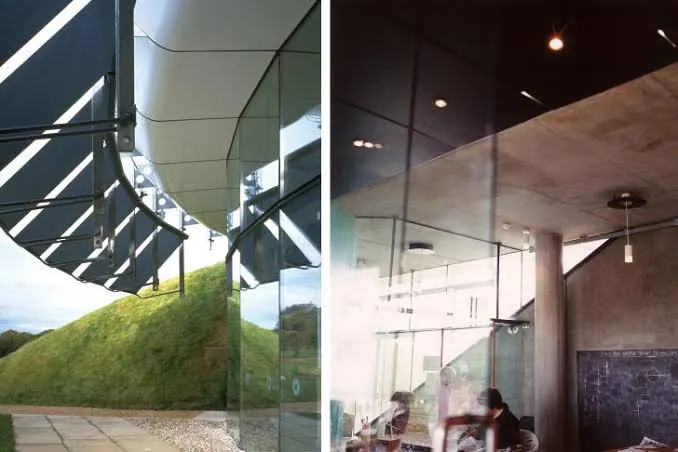 Two-panel image: at left, a glazed entrance beside a steep grass-covered bank under a dark metal canopy; at right, an interior with a curved ceiling, concrete column, glass partition, hanging lights and seated people.