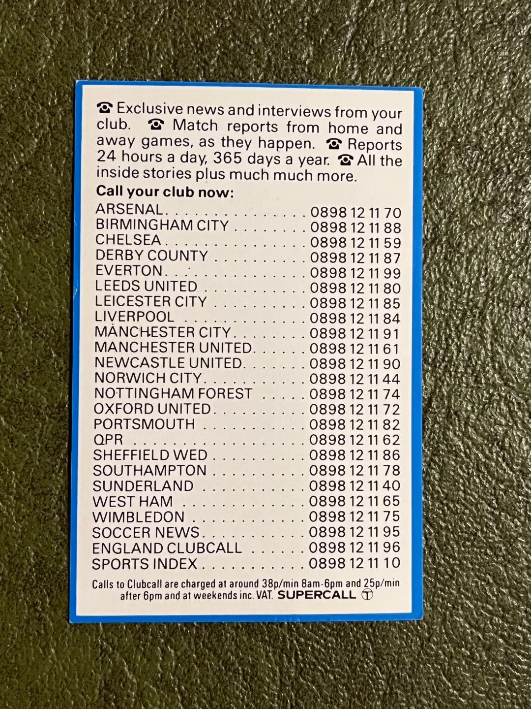 White card with a blue border on a textured dark surface, headed by text promising club news, interviews and match reports. Below is a list of football clubs and 0898 telephone numbers, followed by call charges and a Supercall logo.